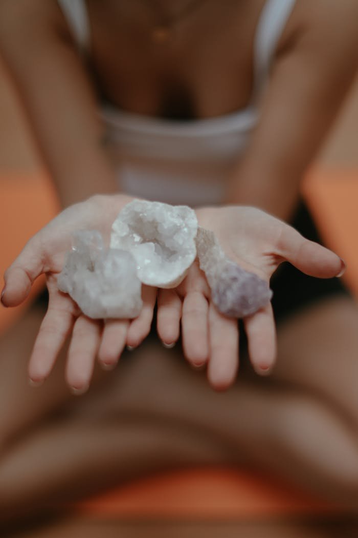 services-03 Close-up of crystals in hands, symbolizing mindfulness and meditation, with a blurred background.